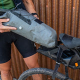 Dry bag being removed from sling in the Blackburn Outpost Elite Universal Seat Bikepacking Pack